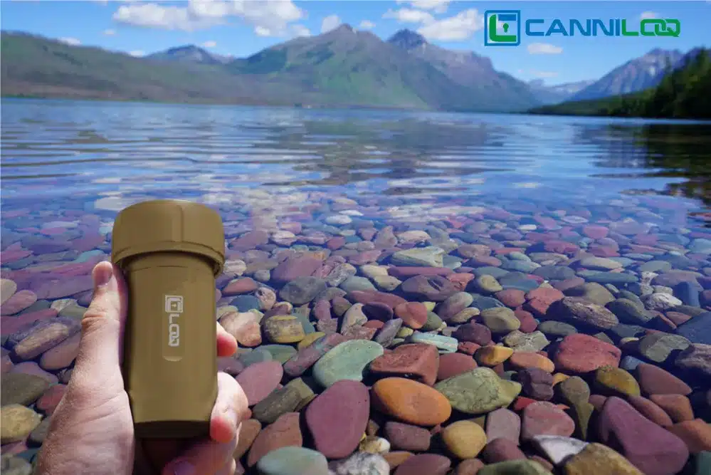 a tan canniloq waterproof herb storage container shown on flathead lake montana